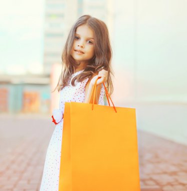 Portrait of beautiful little girl with shopping bag outdoors