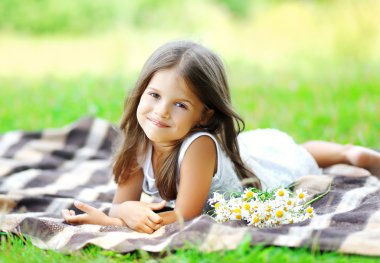 Portrait of beautiful little girl child with chamomiles flowers 