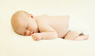 Sweet sleep baby lying on the bed at home