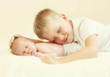 Two children lying sleeping on the bed at home, eldest brother h