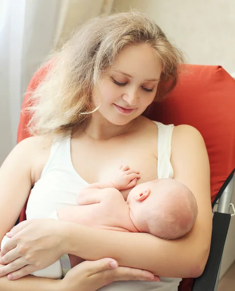 Mamma felice che tiene sulle mani il bambino e che allatta il seno a casa — Foto Stock