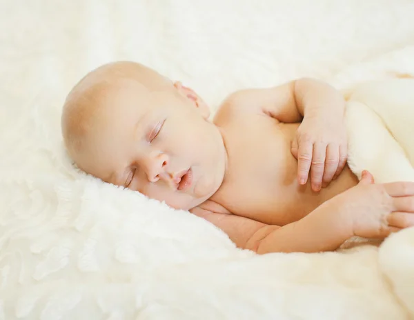 Bebê bonito dorme de lado na cama em casa — Fotografia de Stock