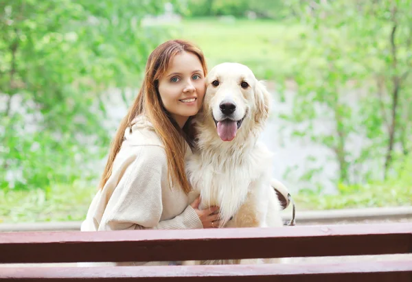 Retrato de la feliz propietaria mujer y perro Golden Retriever sentado t — Foto de Stock