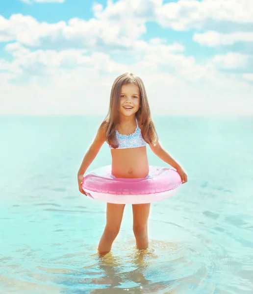 Happy little girl child bathing with inflatable circle and havin — Stok fotoğraf