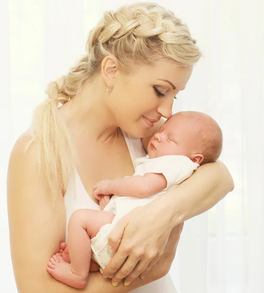 Madre cariñosa sosteniendo las manos durmiendo bebé en casa —  Fotos de Stock