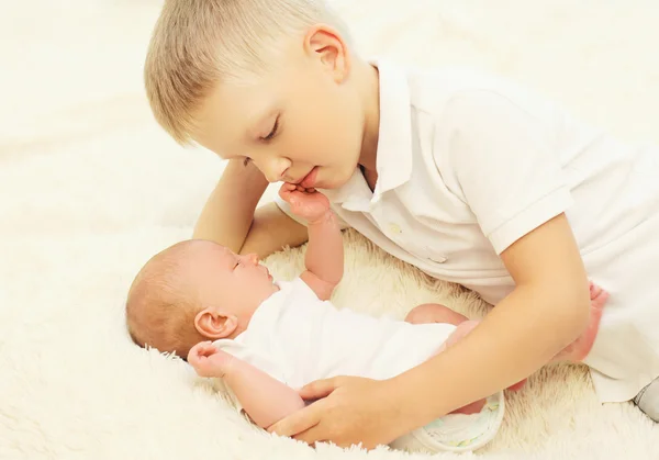 Two children lying on the bed, eldest brother hugging youngest b — Stok fotoğraf