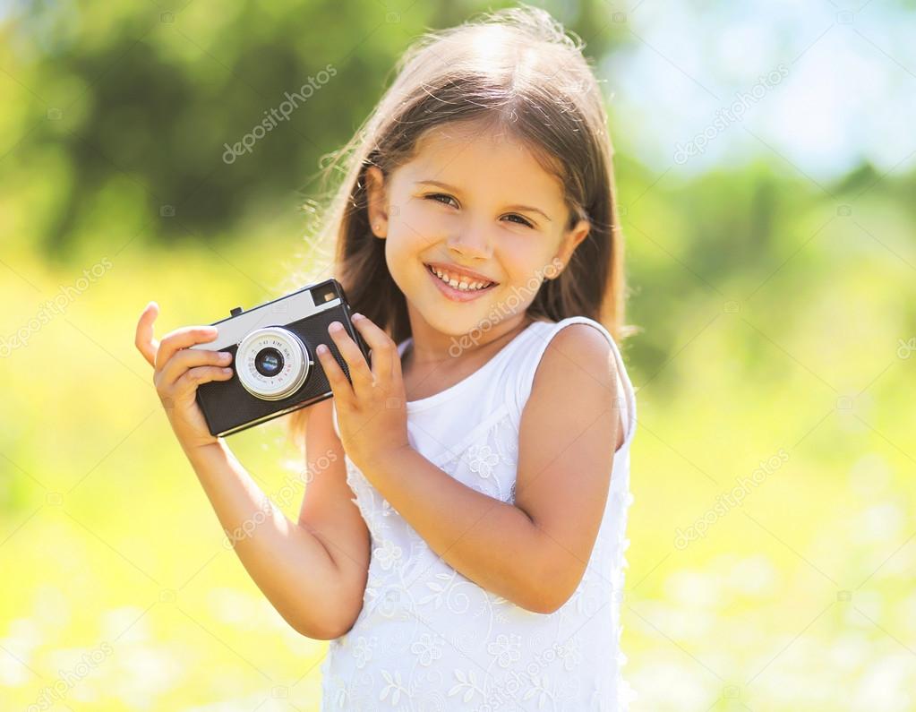 Sunny portrait of cute smiling little girl child with retro vint
