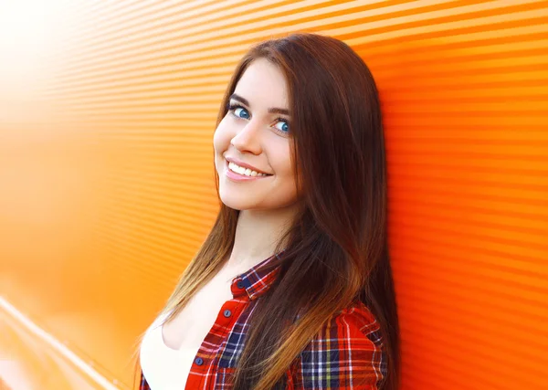 Portrait of beautiful smiling young woman against the colorful w — Stock Photo, Image