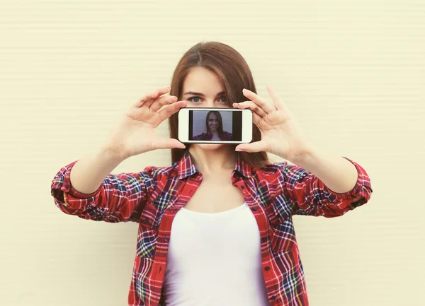 Chica bonita hace autorretrato en el teléfono inteligente al aire libre en th — Foto de Stock