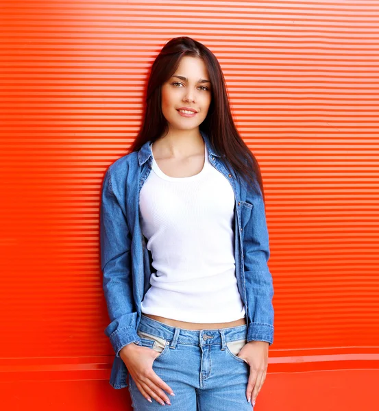 Portrait of pretty brunette woman in jeans clothes against the r — Stock Photo, Image