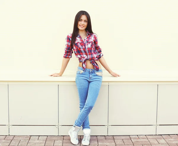 Mulher bonita vestindo uma camisa quadriculada e jeans posando em — Fotografia de Stock