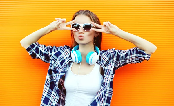 Docela v pohodě holka v sluneční brýle a sluchátka baví proti — Stock fotografie