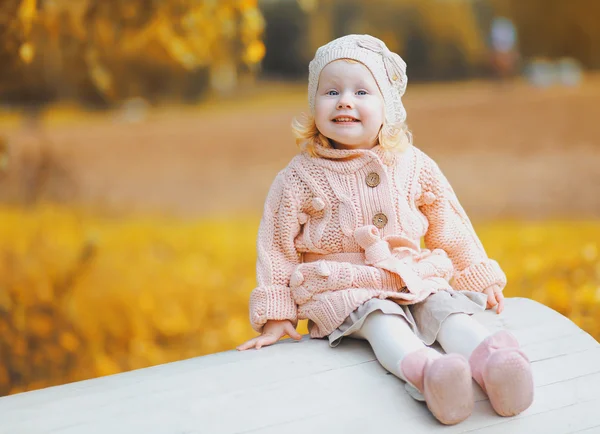 Sevimli küçük çocuk sonbaharda eğleniyor bir örme Giyim Eşyası — Stok fotoğraf