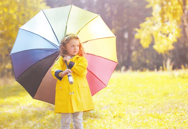 Lindo niño niña en chaqueta amarilla con paraguas colorido o —  Fotos de Stock