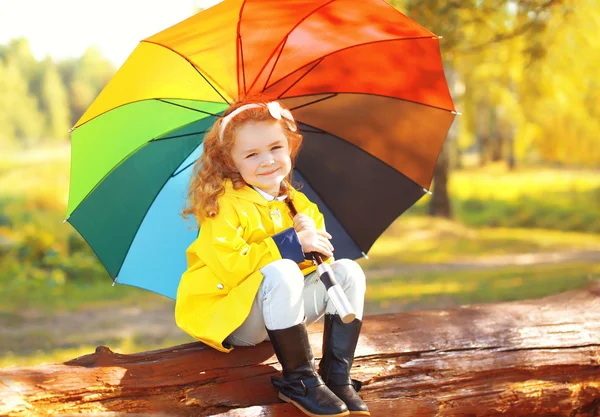 Niña pequeña con paraguas colorido en el soleado parque de otoño —  Fotos de Stock