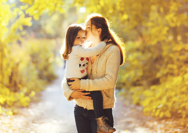 Bonheur, mère ! Maman embrasser enfant dans le parc d'automne ensoleillé — Photo