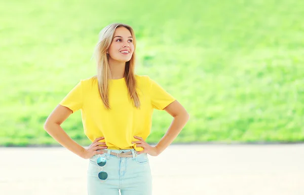 Schöne lächelnde junge Frau in einem bunten gelben T-Shirt — Stockfoto