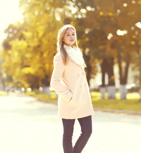 Güneşli sonbahar parkta pembe bir ceket giyen güzel genç kadın — Stok fotoğraf