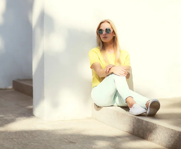 Mode modell kvinnan bär en solglasögon och gul t-shirt sitt — Stockfoto