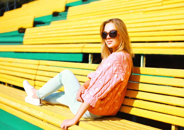 Retrato de moda mujer bastante joven descansando en el banco en el parque —  Fotos de Stock