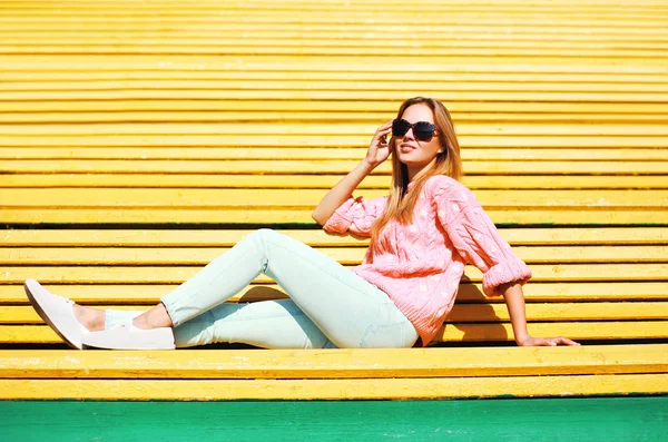 Moda bella donna che riposa su una panchina nel parco — Foto Stock