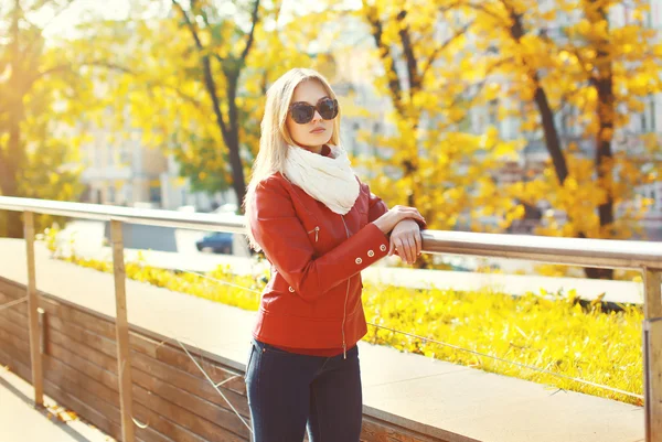 Moda jovem mulher vestindo um óculos de sol e casaco de couro vermelho — Fotografia de Stock