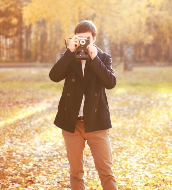 Yakışıklı adam ile sonbahar Park retro vintage fotoğraf makinesi