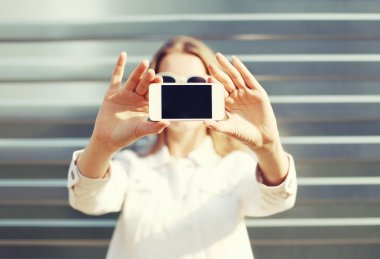 Kadın portresi smartphone cep telefonu ile şehrin görünümünü yapar