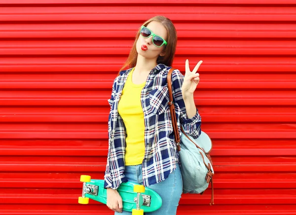 Ganska cool flicka klädd i en solglasögon, skateboard och co — Stockfoto