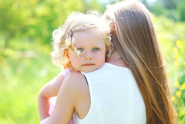 Портрет маленький ребенок обнимает мать на открытом воздухе в летний день — стоковое фото