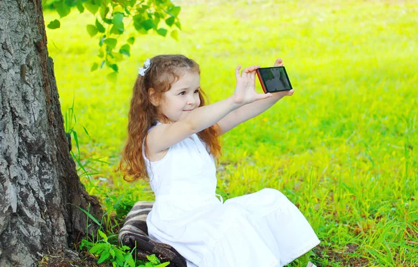 Güzel küçük bir kız çocuk kendi kendine portre Smartphone'da yapma ben — Stok fotoğraf