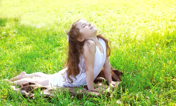 Güneşli yaz da çim üzerinde uzanan yoga egzersiz yaparak çocuk — Stok fotoğraf