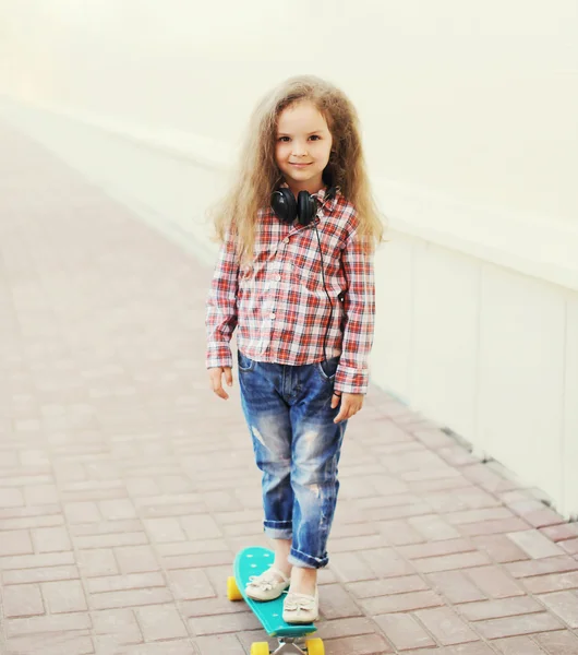Criança menina da moda no skate na cidade — Fotografia de Stock