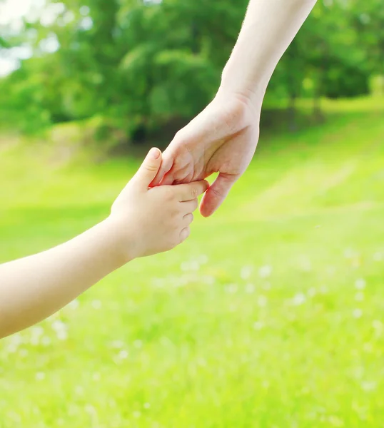 Hand Kind und Hand Mutter Nahaufnahme über Sommer Gras — Stockfoto