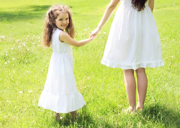Criança feliz de mãos dadas mãe andando no ensolarado prado de verão — Fotografia de Stock