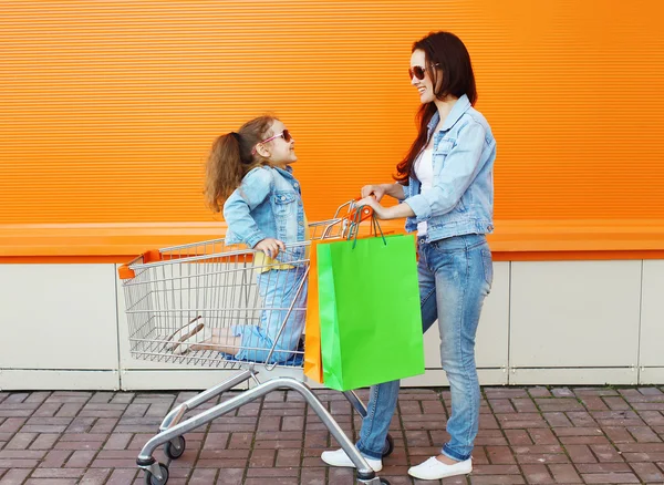 Anne ve çocuk arabası sepeti ve colo ile gülümseyerek mutlu bir aile — Stok fotoğraf