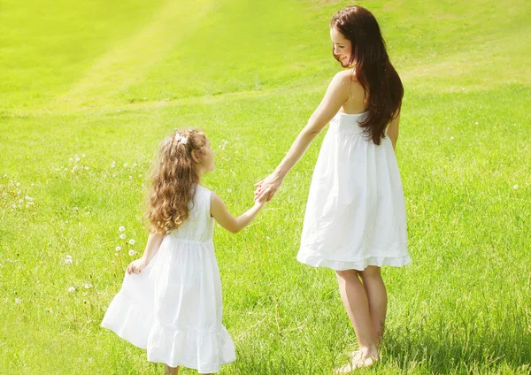 Gelukkig moeder en kind hand in hand wandelen in zonnige zomer mea — Stockfoto