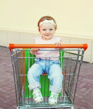 Portre sevimli bebek arabası arabası alışveriş torbaları ile oturma