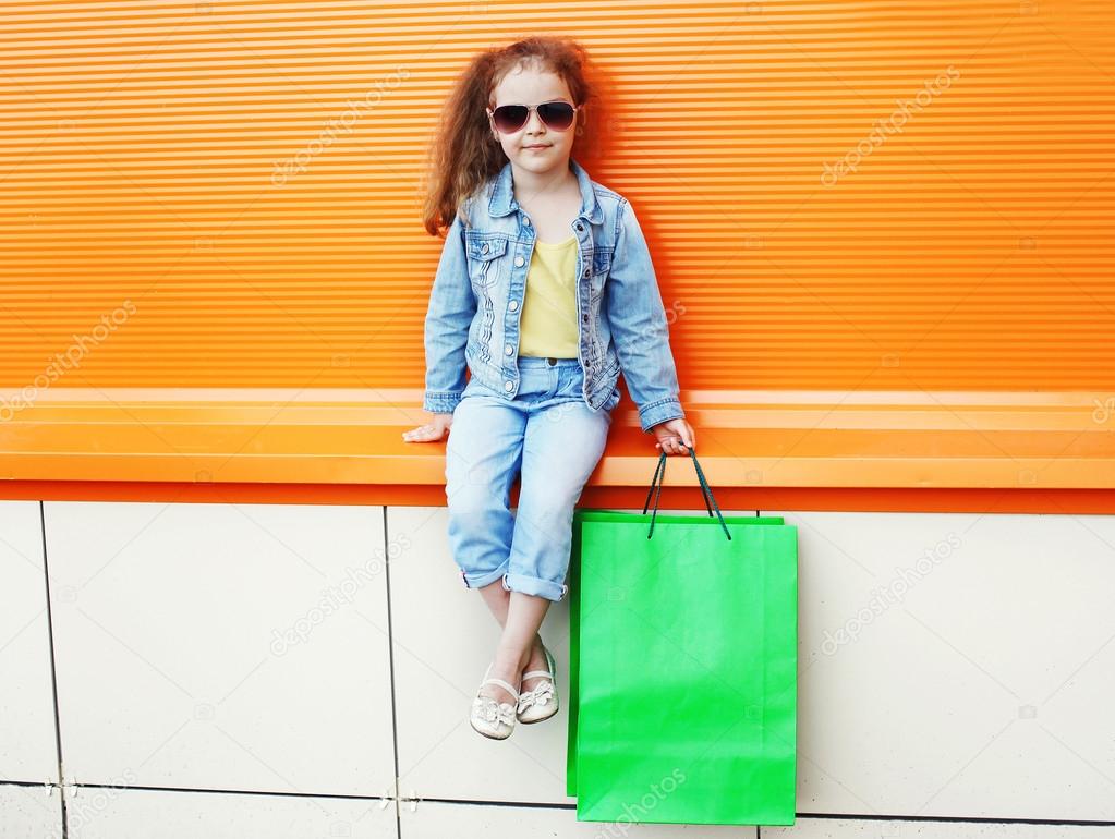 Pretty little girl child wearing a jeans clothes and sunglasses