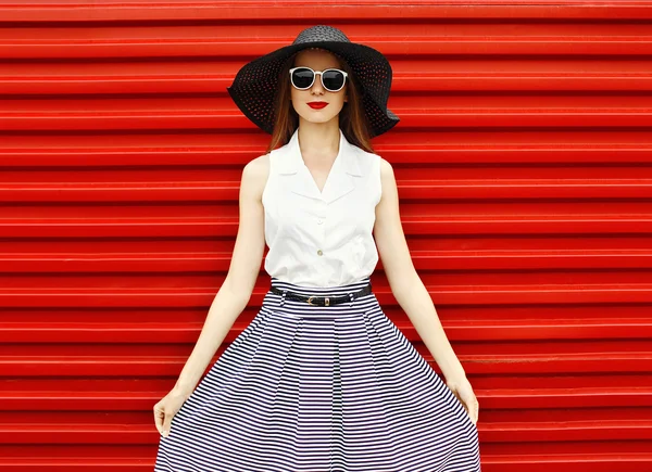 Retrato de moda de una mujer hermosa con un sombrero de paja negro, s — Foto de Stock