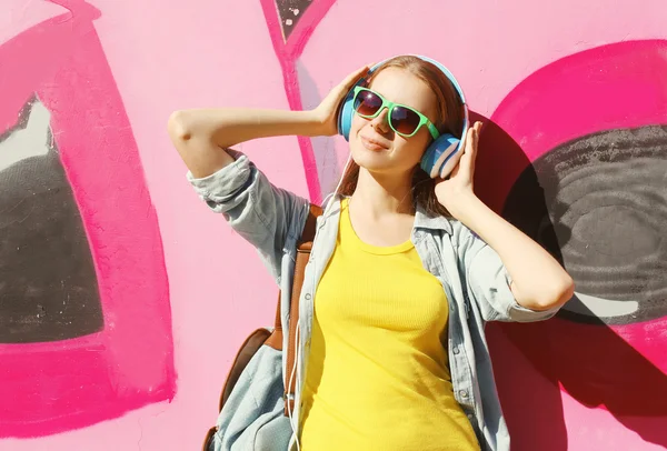 Pretty cool girl wearing a sunglasses, headphones and skateboard — Stockfoto