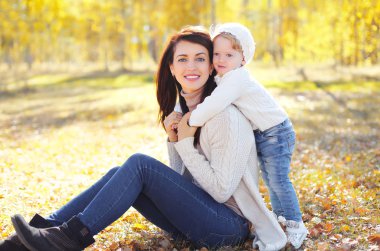 Güneşli sonbahar Park küçük çocuk ile mutlu gülümseyen anne