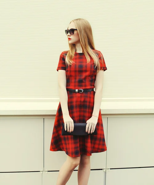 Красивая блондинка в красном платье, солнцезащитные очки с сумкой clu — стоковое фото