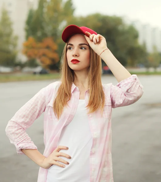 Fashion portrait pretty young girl wearing a shirt and red cap o — Stockfoto