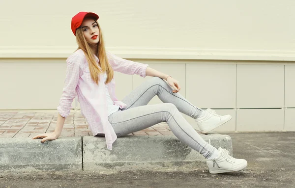 Moda menina bonita vestindo uma camisa e boné vermelho ao ar livre — Fotografia de Stock