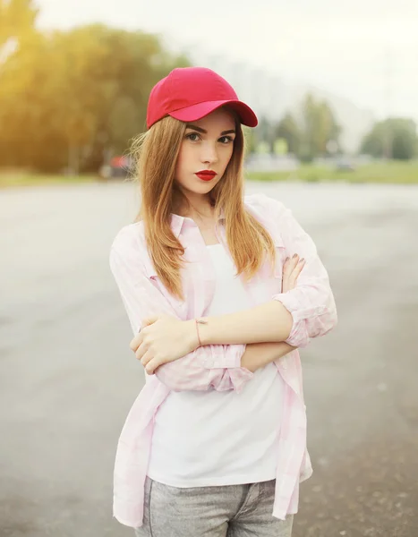 Linda chica joven con una camisa y gorra roja al aire libre — Foto de Stock