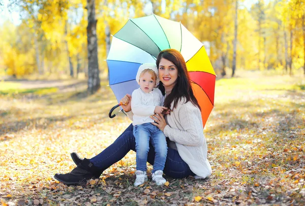 Feliz madre sonriente y el niño con paraguas juntos en otoño —  Fotos de Stock