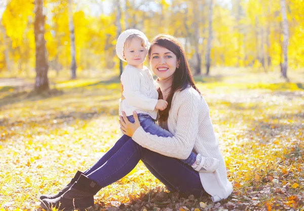 Bonne mère souriante avec un petit enfant jouant en automne ensoleillé p — Photo