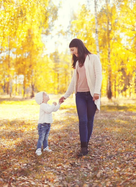 Glada leende mamma promenader med barn i soliga höstdag — Stockfoto