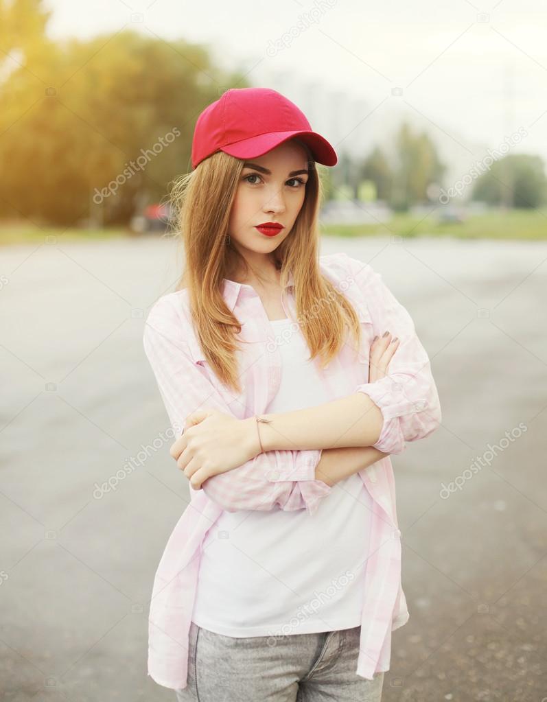 Pretty young girl wearing a shirt and red cap outdoors
